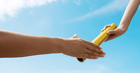 Image of someone's hand passing a baton to another person's outstretched hand.
